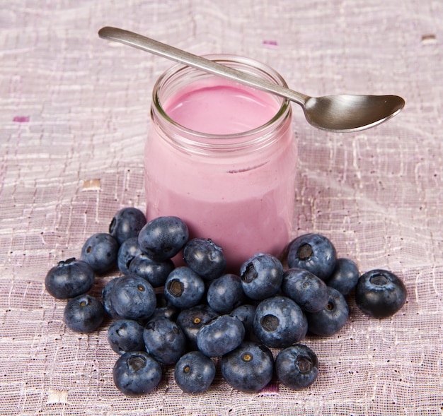 Joghurt und Blaubeeren auf rosa Stoff