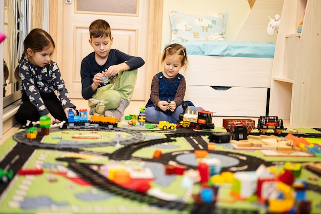 Jogo criativo de atividade de lazer infantil Crianças brincam em casa com trem de brinquedo