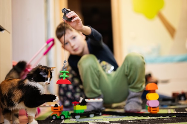 Jogo criativo de atividade de lazer infantil Irmão e irmã brincam em casa Menino com gato