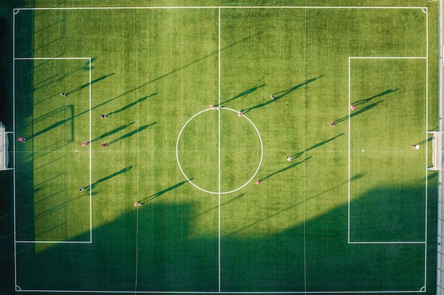 Jogo de futebol em campo verde à luz do pôr-do-sol