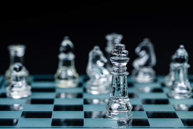 Jogo de tabuleiro de xadrez de vidro em foco seletivo de fundo preto no conceito de vencedor do rei