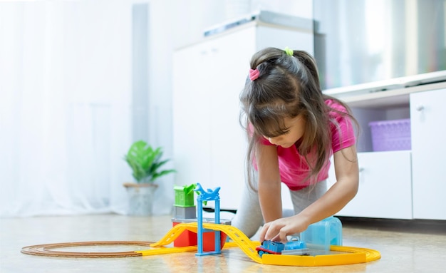 Jogo do bebê. criança caucasiana inteligente brincando de trem de brinquedo colorido e treinar para o desenvolvimento inicial.