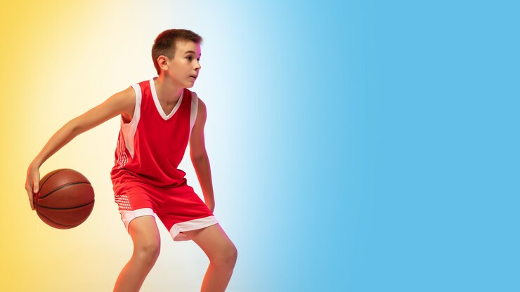 Foto jogo. retrato de jovem jogador de basquete de uniforme em gradiente