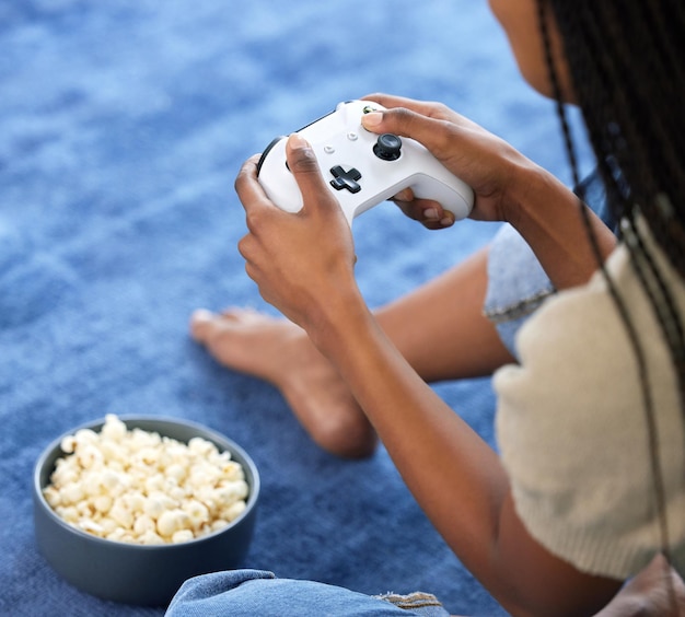 Jogos de vídeo de mulher e mãos jogando no chão de casa com pipoca para gamepad de jogos online e relaxe Jogador joga no joystick do console ou controle para streaming de esports e tecnologia do mundo cibernético