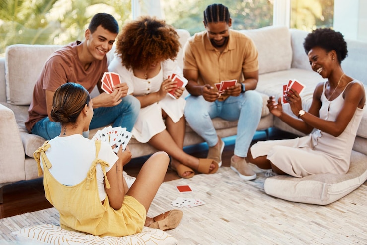 Foto jogue cartas felizes ou amigos jogando pôquer ou black jack em casa para jogar juntos em uma festa de natal sorria homens ou grupos de mulheres rindo para relaxar na sala de estar em uma divertida competição de jogos