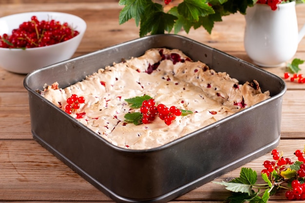 Foto johannisbeer-käsekuchen-torte mit frischen beeren auf holztisch