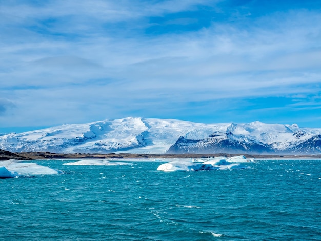 Jokulsarlon-Eisberglagune mit Gletscher und großem Eisberg unter bewölktem blauem Himmel in Island