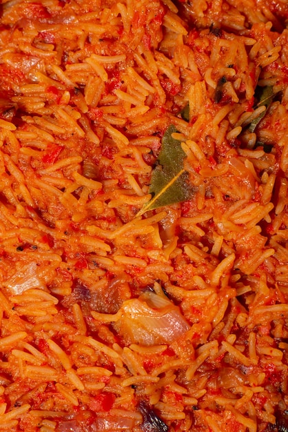 Jollof-Reis closeup Hintergrund von Reis gekocht in Tomatenmark mit Gewürzen