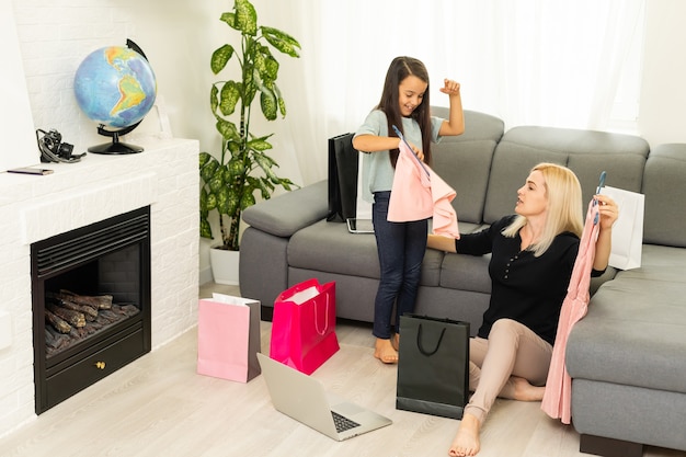 Jolly madre y su hija se divierten en casa después de las compras