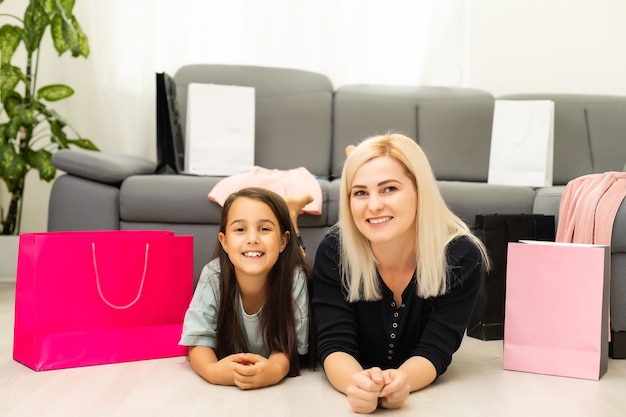 Jolly madre y su hija se divierten en casa después de las compras