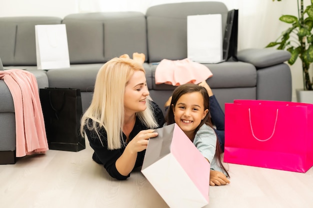 Jolly madre y su hija se divierten en casa después de ir de compras