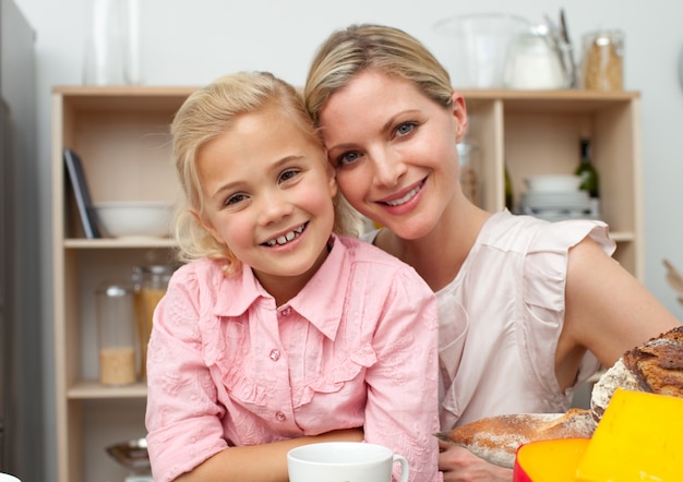 Jolly menina comendo frutas com sua mãe