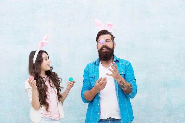 Jonglier-Ei Spaß auf der Ostereiersuche Glückliche Familie, die sich auf Ostern vorbereitet Glückliche Zeit mit der Familie Vater und Tochter feiern Ostern lächelnd und lachend Kaninchen-Partyzeit, die den Urlaub vorbereitet