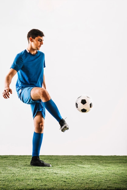 Foto jonglierender ball des jungen fußballspielers