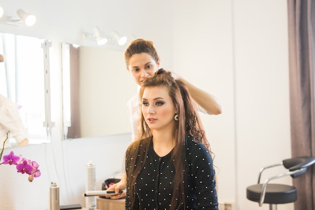 Jornada laboral dentro del salón de belleza. El peluquero hace el peinado del cabello.