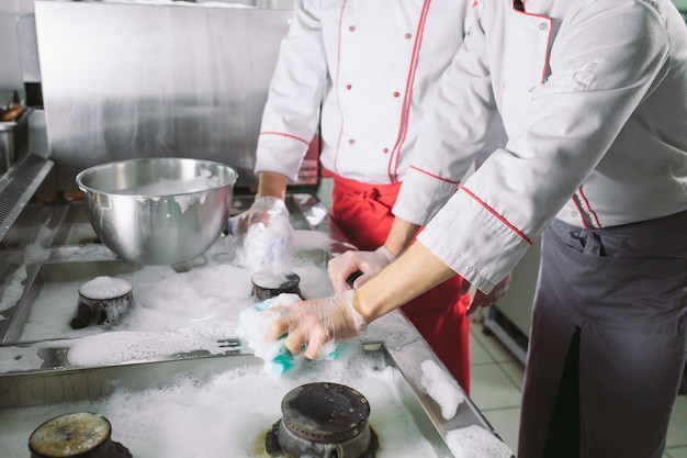 Foto jornada sanitaria en el restaurante. repite lavar tu lugar de trabajo. cocina lava horno, estufa y extractor en el restaurante.