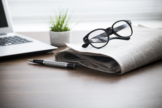 Jornal com computador na mesa