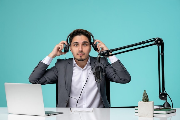 Jornalista blogueiro bonitinho rapaz bonito de terno cinza gravando vídeo no fone de ouvido