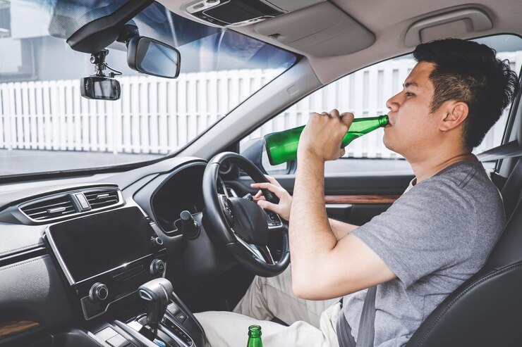 Foto jovem a beber cerveja de garrafa enquanto dirige um carro