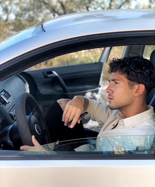 Foto jovem a conduzir um carro.