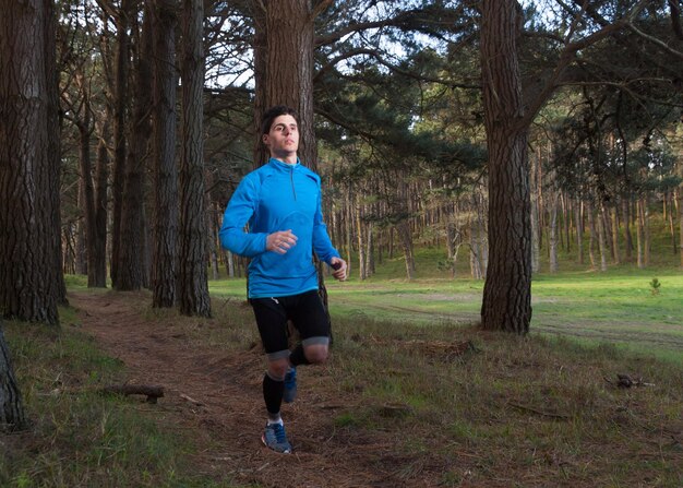 Foto jovem a correr na floresta