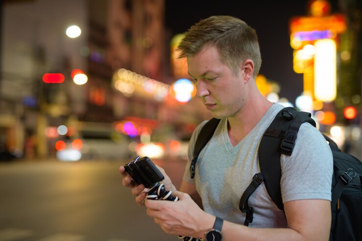 Foto jovem a usar telemóvel à noite