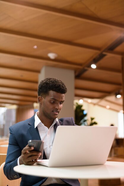 Jovem a usar telemóvel num portátil