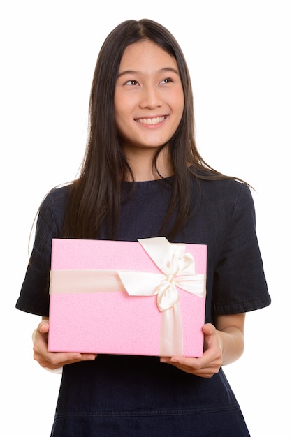 Jovem adolescente asiática feliz sorrindo e segurando uma caixa de presente