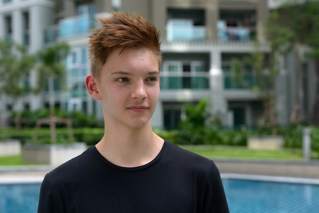 Jovem adolescente bonito com cabelo loiro ao ar livre