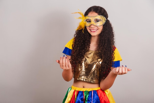 Jovem adolescente brasileira com máscara de carnaval de roupas de frevo convidando com as mãos