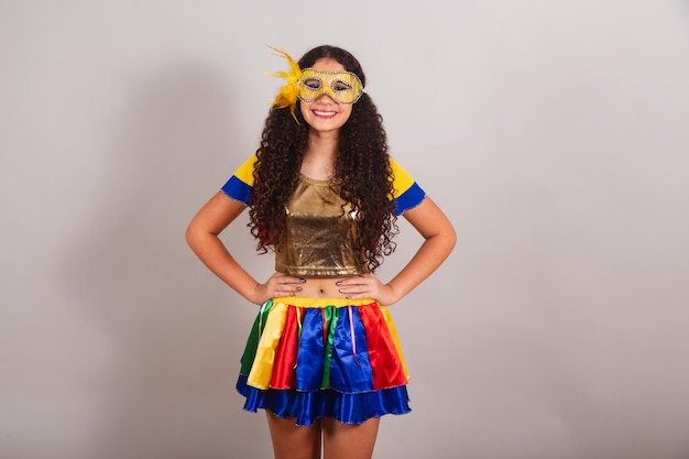 Jovem adolescente brasileira com roupas de frevo Máscara de carnaval mãos nos quadris posando para foto