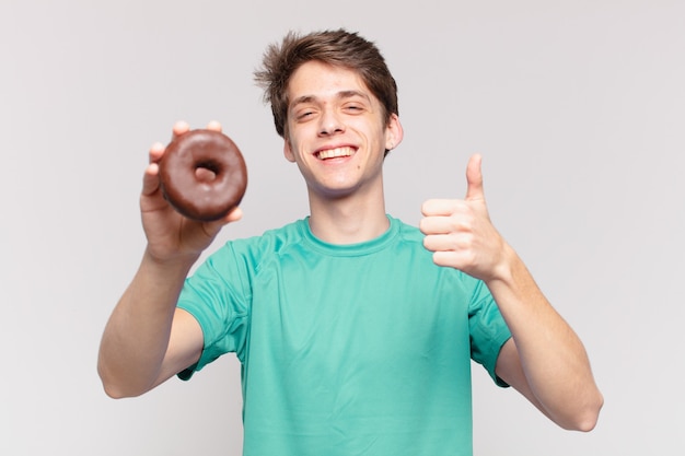 Jovem adolescente com expressão feliz e segurando uma rosquinha