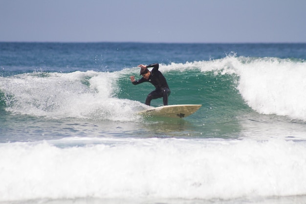 Jovem adolescente curtindo o surf no oceano