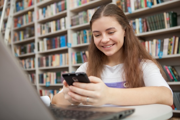 Jovem adolescente estudando na biblioteca