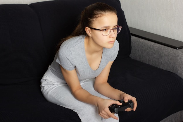 Jovem adolescente europeia de cabelos escuros joga videogame em casa Desgosto de emoções reais