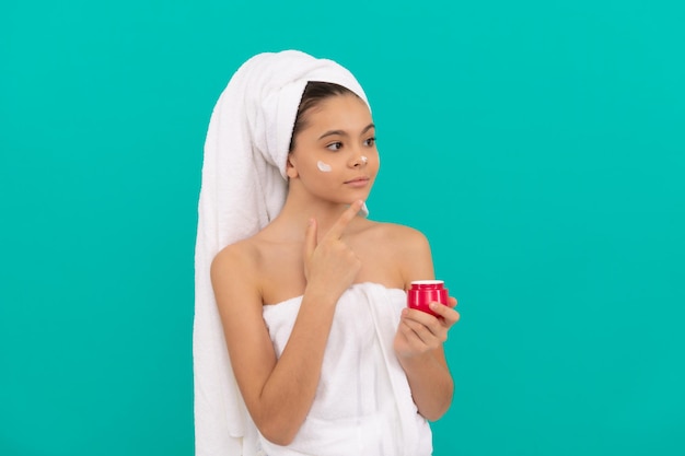 Jovem adolescente na torre de banho aplicando o corpo cosmético, pele saudável.