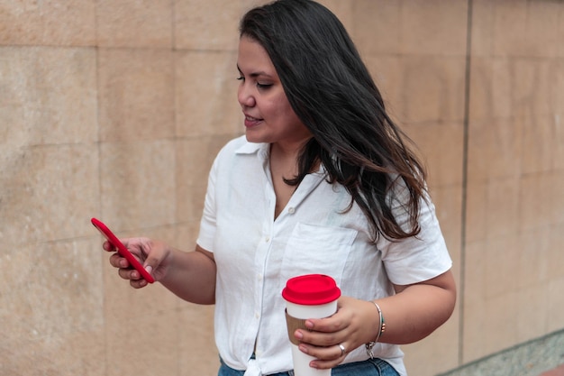 Jovem adolescente olhando para o celular na rua