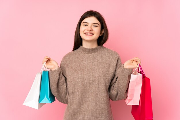 Jovem adolescente segurando sacolas de compras e sorrindo