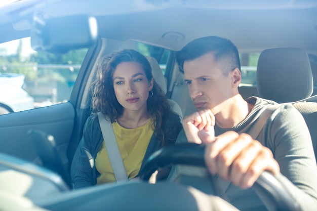 Jovem adulta e homem no interior do carro novo