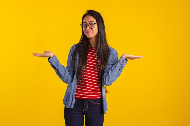 Jovem adulta em fotos de estúdio fazendo expressões faciais e usando os dedos e as mãos