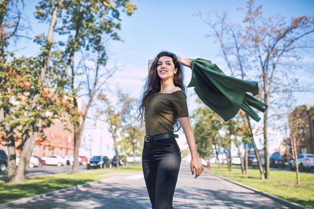 Jovem adulta linda morena com roupas casuais feliz andando pela cidade