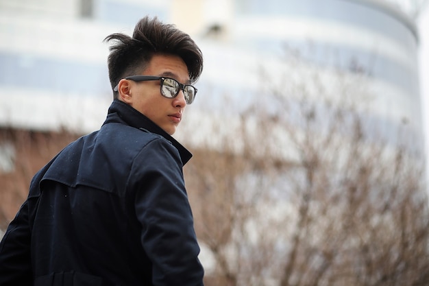 Jovem adulto asiático na rua, posando para a câmera