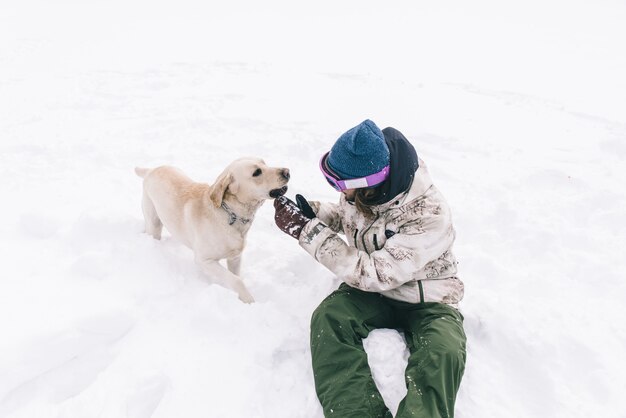 Jovem adulto brincando com seu cachorro