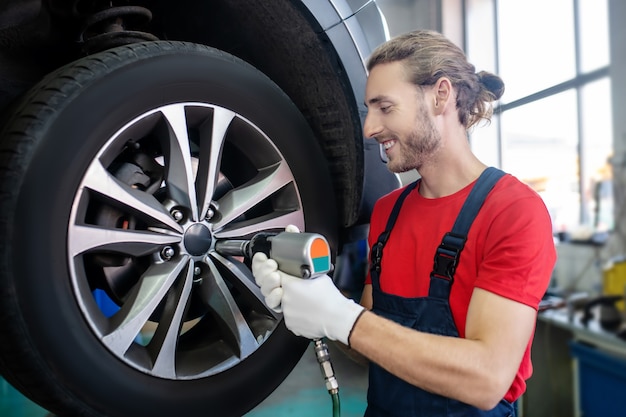 Jovem adulto confiante em uniforme de trabalho, trabalhando em carros