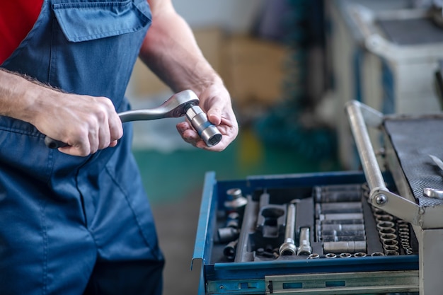 Jovem adulto confiante em uniforme de trabalho, trabalhando em carros