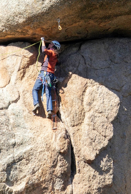 Jovem adulto escalando uma saliência de granito em Torrelodones Madrid Escalada Conceito de esportes radicais