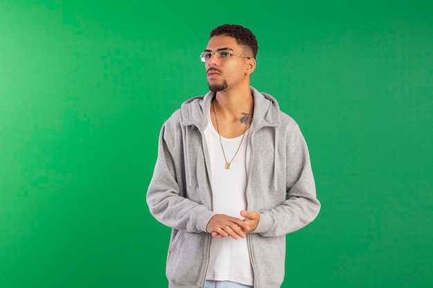 Jovem adulto estilo hip hop em foto de estúdio com fundo verde ideal para corte