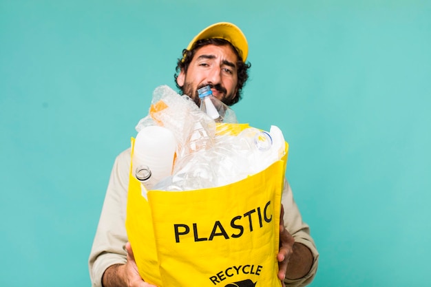 Jovem adulto hispânico louco reciclando um conceito de ecologia