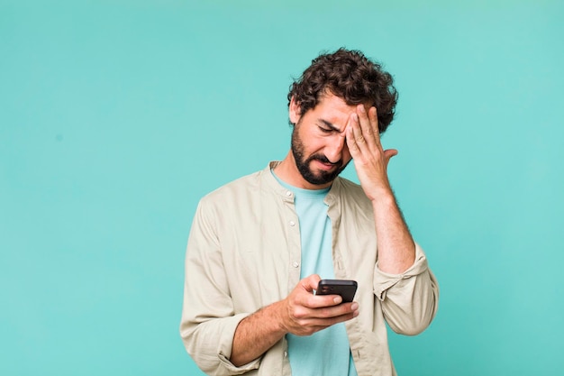 Jovem adulto hispânico louco usando seu telefone