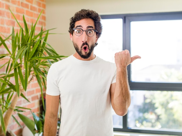 Jovem adulto louco com pose expressiva no interior de uma casa moderna